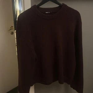 Vinröd stickad tröja från Gina Tricot - Säljer en mysig vinröd stickad tröja från Gina Tricot. Tröjan har en rund halsringning och långa ärmar, perfekt för kyligare dagar. Den är enkel och stilren, vilket gör den lätt att matcha med olika outfits.