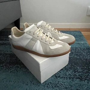 Maison Margiela GATS  - Tjena!  Säljer nu mina Maison Margiela gats som är sparsamt använda. Dessa är självklart äkta, retur blanketten hittar du på sista bilden. Dessa har för det mesta legat runt och samlat damm, skulle säga att de är i 9/10 skick, kanske 1-2 fläckar man knappast ser (detaljerad bild på bild 4).   Med dessa medföljer: original box (ganska skadad), 2 dust bags (bild 2), retur blankett (verifierar äktheten) och 2 formstöd billigt plast.  Hör av er om ni har frågor!