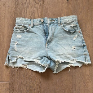 Ljusa jeansshorts med slitningar - Säljer ett par ljusa jeansshorts med coola slitningar och fransiga kanter. Pris kan diskuteras 