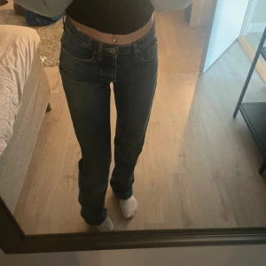 Blå jeans med bootcut - Säljer mina snygga zara jeans! Mid waist i stl 32, inte super använda men dock har jag klivit på jeansen lite längst ner så de har blivit slitet men själv tycker jag de är snygg detalj! Jag är 164