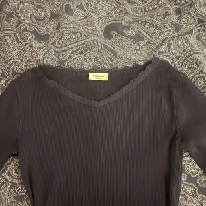 Marinblå ribbad topp från Kappahl - Säljer en marinblå ribbad topp från Kappahl med spetsdetaljer vid halsringningen. Toppen har långa ärmar och en v-ringad design. Den liknar även intimissmi tröjans design! 💞pris kan diskuteras!