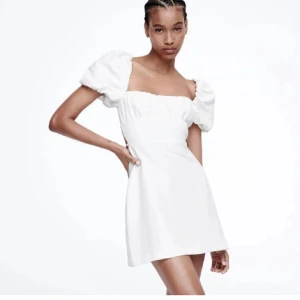 Vit kortklänning med puffärmar - Snygg vit kortklänning med puffiga kortärmar och en öppen rygg med snörining. Använd 1 gång och har inga defekter storlek S från Zara💙