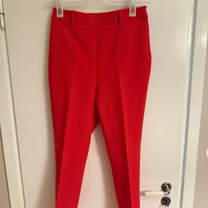 Röda kostymbyxor - Snygga röda kostymbyxor med en elegant och stilren design. Byxorna har en hög midja och raka ben som ger en klassisk look. Perfekta för att addera en färgklick till din garderob. Köpta för 600 på zara och använda en gång❤️