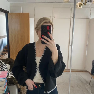 Svart omlottjacka med vita detaljer - Kofta från Gina, knappt använd