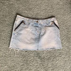 Lågmidjad jeanskjol  - Ljusblå lågmidjad jeanskjol. Midjemått:40,5 cm Längd: 31 cm