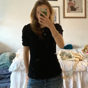 Svart topp från VILA - Säljer en svart topp från VILA med korta puffärmar och ett texturerat mönster. Jättebra skick! Pris kan diskuteras, tryck gärna på köp nu!💗💗