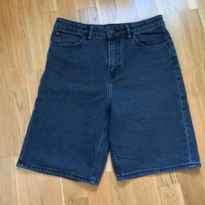 Svarta jeansshorts från H&M - Säljer ett par svarta jeansshorts från H&M med justerbar midja. Shortsen har en loose passform och klassisk femficksdesign. Perfekta för en avslappnad stil.