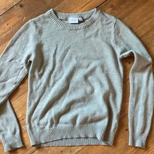 Ljusgrön stickad tröja från VILA - Säljer en supermysig ljusgrön stickad tröja från VILA. Den har en rund halsringning och långa ärmar. Perfekt för höst och vinter! Tröjan är i bra skick och passar till både jeans och kjol. Köp den nu och håll dig varm och snygg! 💛