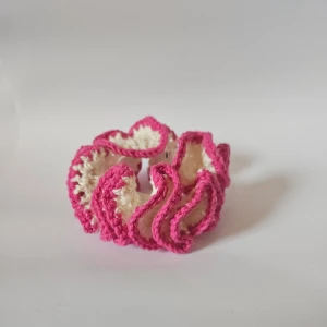 Handgjort virkat armband i rosa och vitt - Superfin virkad scrunchie i rosa och vit. Perfekt för att piffa upp vilken frisyr som helst! Den är mjuk och elastisk, vilket gör den skonsam mot håret. Passar både till vardags och festliga tillfällen.