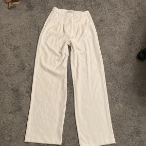 vita kostymbyxor - jättefina byxor men är för långa för mig. använd endast 2-3 gånger // inga defekter. högmidjade med pläteringsdetaljer och köpta utomlands. raka i benen och sitter löst/baggy. Skriv om du har frågor🌟