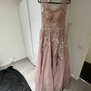 Klänning - Festklänning till salu. Storlek 36. Pris 1 00kr går att diskuteras vid snabb affär. Går att fraktas. Köpare står för frakt. Babyrosa färg med glitter detaljer. Köpt ifrån R&F helsingborg. Har påsen kvar från affären. 