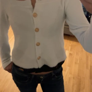 Vit kofta - Stl:M passar S En vit mysig kofta med guldiga knappar. Knappt använd. Liten i storleken