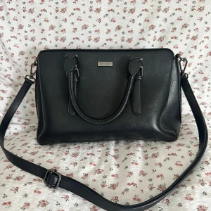 Svart axelväska - Säljer en svart axelväska från Don Donna. Väskan är i skinn och har både handtag och en justerbar axelrem, vilket gör den superflexibel att bära o en liten bakficka. Insidan är lite sliten vid toppen men annars i bra skick. Vid intresse, skriv först💕