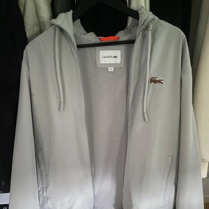 Lacsoste Windbreaker - Hej. Säljer denna vindjacka som passar perfekt till vår och höst då den är lite tjockare och varmare än andra vindjackor. Skick 8/10 ny och knappt använd. Köpt på Zalando för 1200kr (på rea) slutsåld. Ny pris: 2000kr. Kvitto finns. 