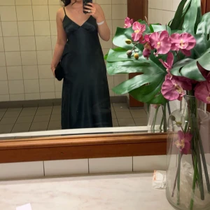 Mörkgrön balklänning  - Balklänning från ByStina, endast använd 1 gång. Har två revor på fram och baksida men inget som syns från långt håll. Storlek M i regular, passar i längden på mig som är 170 cm.