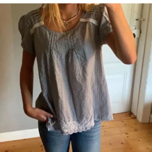 Randig blus från Flash woman  - Säljer en söt randig blus från Flash woman i storlek M. Blusen har korta ärmar och fina spetsdetaljer vid axlarna och nederkanten. Perfekt för en avslappnad stil med en touch av elegans.