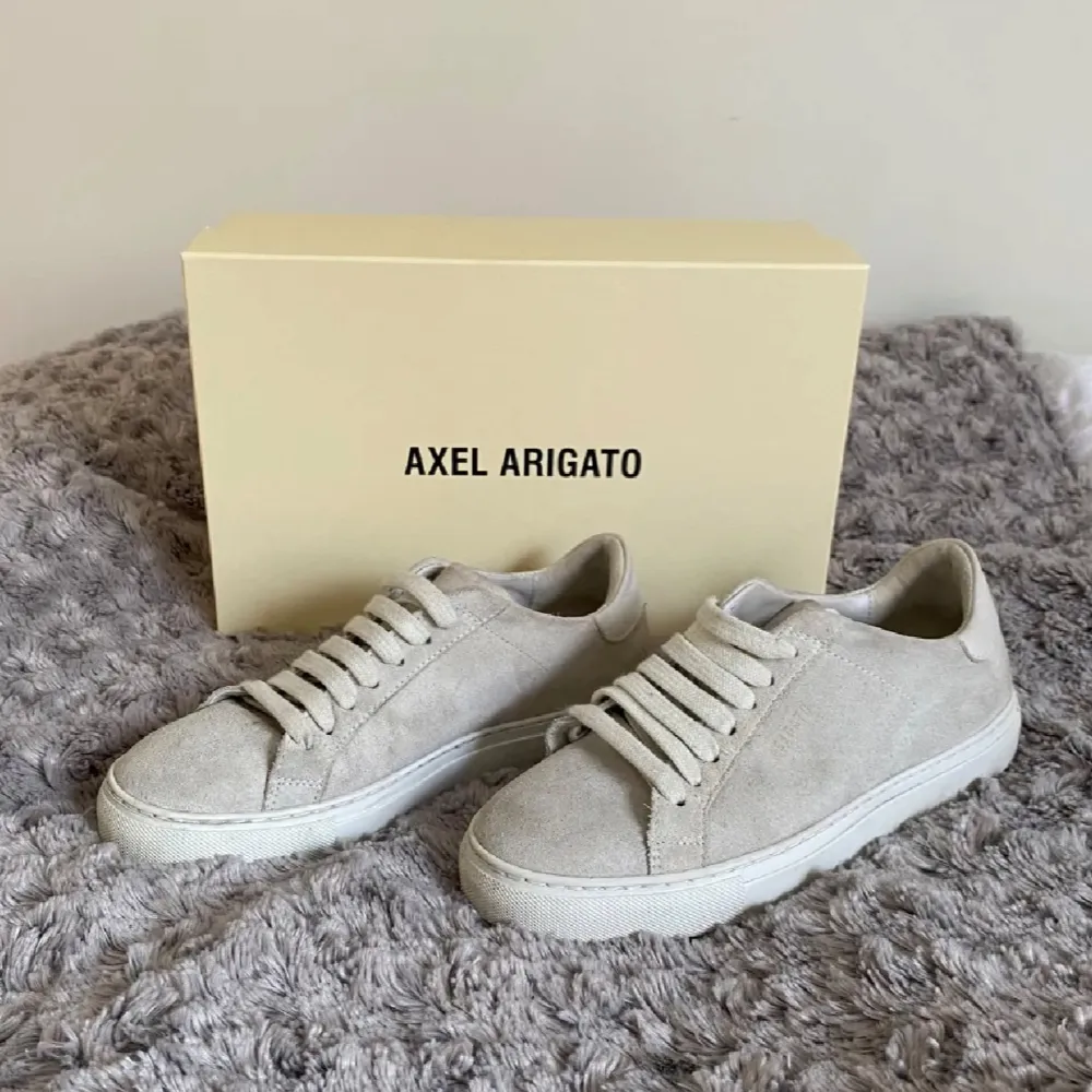 Snygga beige sneakers från Axel Arigato i modellen Clean 90 C90 Version Suede. Skorna har en stilren design med snörning och är tillverkade i mocka med en vit sula. Storlek 35, passar 36 också. Kengät.