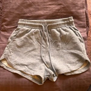 Ljusblå mjukishorts  - Säljer ett par ljusblå mjukisshorts med elastisk midja och dragsko från H&M i storlek XS. Shortsen har en avslappnad passform och är perfekta för en chill dag hemma eller lätt träning. De är tillverkade i ett mjukt och bekvämt material. Nästan aldrig använda. 