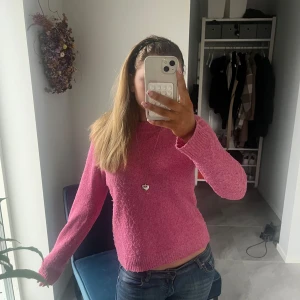 Rosa stickad tröja - Säljer en söt rosa stickad tröja med långa ärmar. Perfekt för att hålla sig varm och stilren under kyligare dagar. Tröjan har en enkel design som gör den lätt att matcha med olika outfits. Passar perfekt för både vardag och speciella tillfällen.