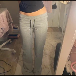 Grå mjukisbyxor med snörning - Säljer ett par bekväma grå mjukisbyxor med snörning i midjan. Byxorna har en avslappnad passform och är perfekta för en chill dag hemma. De är tillverkade i ett mjukt material som känns skönt mot huden. Klippta kortare än vad de egentligen ska vara.