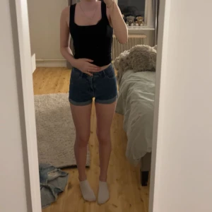 Blå jeansshorts - Mörk blå jeansshorts från h&m. De är mid waist och är i storleken 34 men är vädligt stretchiga i materialet, vilket gör de bekvämare.
