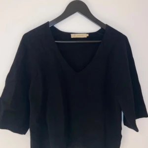 Svart tröja från Peppercorn - Säljer en stilren svart tröja från Peppercorn med v-ringad hals. Tröjan har trekvartsärmar och är perfekt för en elegant look. Passar bra till både jeans och kjol.