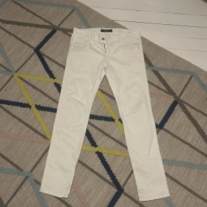 Vita jeansbyxor från Replay - Snygga vita jeansbyxor från Replay i modellen Anbass. De har en slim passform och är tillverkade i ett bekvämt material med dragkedja och knapp framtill. Perfekta för en stilren look.