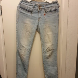Ljusblå lågmidjade jeans - Snygga ljusblå jeans i slim fit med låg midja. De har coola dragkedjedetaljer framtill och klassiska bakfickor. Perfekta för en avslappnad stil.