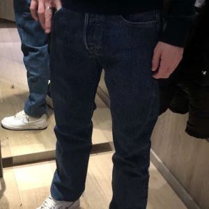Blå jeansbyxor - Klassiska blå jeans med en straight passform. De har en midwaist design och är perfekta för en avslappnad stil. Byxorna har en dragkedja och knappar framtill. Från Levis, nypris 1200, storlek 33/33