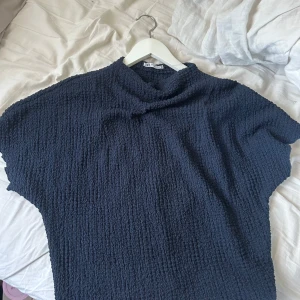 Mörkblå topp från Zara - Säljer en mörkblå topp från Zara med en texturerad yta. Toppen har korta ärmar och en lös passform, tröjan är i strl L men skulle säga att den passar M-S! Pris kan diskuteras💕