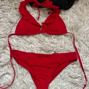 Röd bikini från Tezenis - Snygg röd bikini från Tezenis med volangdetaljer på toppen och knytband i nacken. Helt oanvänd!!❤️