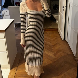 Randig ribbad klänning - Den virala klänningen från Zara som är slutsåld överallt. Snygg långklänning med randigt mönster i beige och svart. Klänningen har en ribbad struktur och långa ärmar. Den är figurnära och har en v-ringad halslinje.