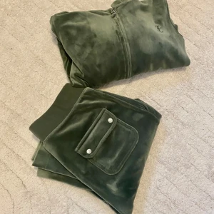 Grön velour hoodie och byxor - Säljer en mysig grön velour hoodie med matchande byxor. Hoodien har dragkedja och byxorna har praktiska fickor med knappar. Perfekt för en avslappnad stil. Överdel storlek s byxa xs
