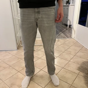 Grå jeansbyxor - Snygga grå jeansbyxor med en straight passform. Perfekta för en avslappnad stil. De har en klassisk design med fem fickor och knappgylf.