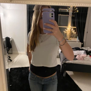Vit croppad t-shirt - Säljer en enkel och stilren vit croppad t-shirt med korta ärmar. Perfekt för en avslappnad look. Passar bra till jeans eller kjol.