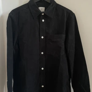 Svart manchesterskjorta från H&M - Svart manchesterskjorta från H&M i storlek S. Väldigt fint skick, använd ett fåtal gånger.
