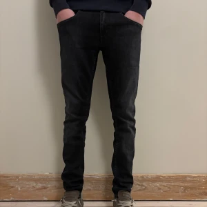 Svarta Tiger of sweden jeans  - Snygga svarta jeansbyxor med en tight passform. Storlek 30/32. Modellen på bilden är 178 cm lång.