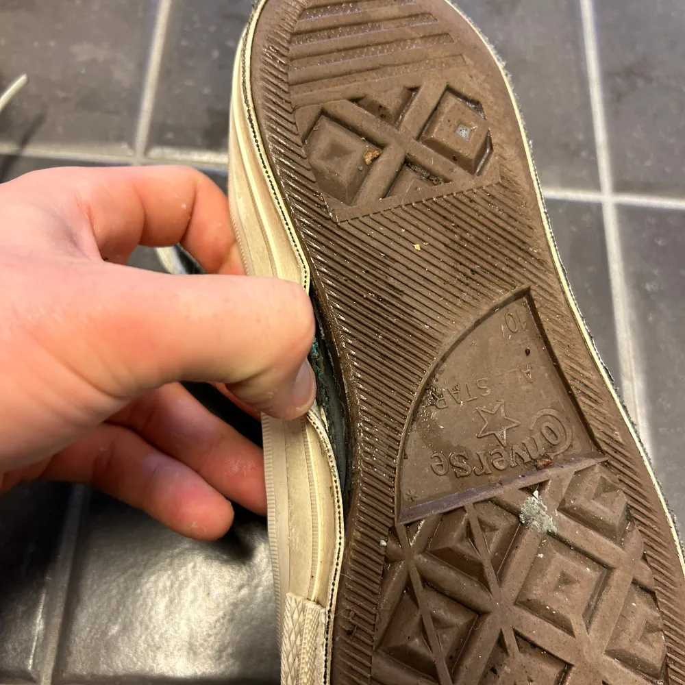 Säljer ett par svarta Converse sneakers med en röd hjärtdetalj på sidan. Skorna har vita snören och en klassisk gummisula. Perfekta för en avslappnad stil.. Kengät.
