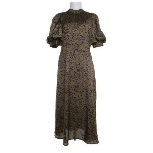 Mönstrad långklänning från Vila - Snygg långklänning från Vila i ett coolt leopardmönster. Klänningen har korta puffärmar och en liten öppning i ryggen. Tillverkad i 100% polyester.