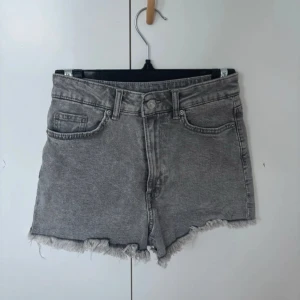 Grå jeansshorts med fransar - Säljer ett par grå jeansshorts i mycket bra skick från H&M! De är högmidjade med och har snygga fransar längst ner. Använda ett par få gånger men inga skavanker!