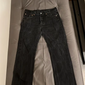 Svarta Levi's 501 jeans - Säljer ett par klassiska svarta Levi's 501 jeans i bra skick. De har en straight passform och är tillverkade i slitstarkt denim. Perfekta för både vardag och fest! 🖤 storlek W32 L30.