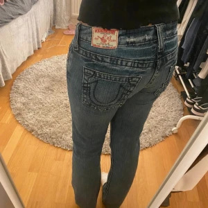 True religion jeans  - Säljer ett par snygga blå jeans med broderad detalj på bakfickan. De har en klassisk passform och är perfekta för vardagsbruk. Jeansen är i bra skick och har en bekväm lowwaist. Perfekta för både höst och vår! Säljer för dem börjar bli försmå för mig 