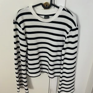 Randig stickad tröja från Gina Tricot - Säljer en superfin randig stickad tröja från Gina Tricot i storlek S. Den är vit med svarta ränder och har långa ärmar. Perfekt för både höst och vår! Tröjan är i mycket bra skick och passar till alla tillfällen. 🖤🤍