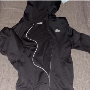 Svart hoodie från Lacoste - Säljer en svart hoodie från Lacoste i mycket bra skick. 
