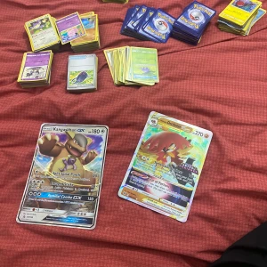Pokémon kort - Samling av Pokémon-kort med olika motiv och sällsynthet. Inkluderar kort med karaktärer som Charizard och Pikachu i olika versioner, inklusive VMAX och GX. Vissa kort har en guldig design vilket ger dem ett exklusivt utseende. Perfekt för samlare eller Pokémon-entusiaster som vill utöka sin kollektion. Första bilden har 660 kort och en pärm som är fylld. Pris kan diskuteras vid snabb köp