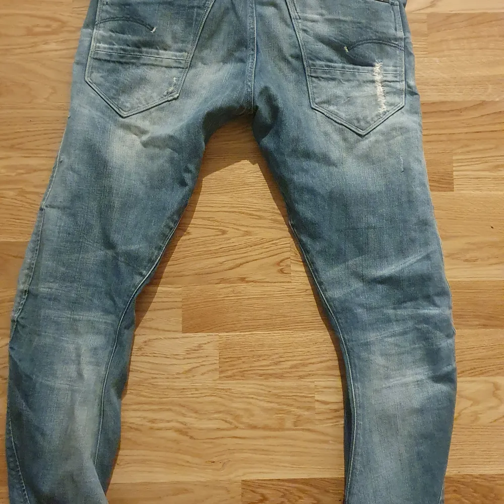 Säljer ett par snygga blå jeans från G-Star i storlek 25/32. De har en cool slitning på framsidan och är i en klassisk denimstil. Perfekta för en avslappnad look! 🕶️. Jeans & Byxor.