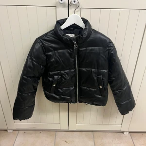 Svart pufferjacka från H&M - Säljer en snygg svart pufferjacka från H&M i storlek 140 den är i mycket bra skick. Jackan har en dragkedja framtill och praktiska fickor med knappar. Perfekt för kyliga höst- och vinterdagar. Den är både stilren och varm, vilket gör den till ett måste i garderoben! Köpte den för 600 kr. 