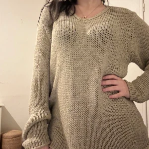 Beige stickad tröja - Säljer en supermysig beige stickad tröja i loose fit. Perfekt för kyliga höst- och vinterdagar. Tröjan har en v-ringad hals och långa ärmar, vilket gör den både stilren och bekväm. Passar perfekt till både jeans och leggings!
