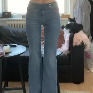 Säljer ett par snygga blå bootcut jeans i mycket bra skick. De är midwaist med fina knappar fram och stretch. Är i storlek 36💕