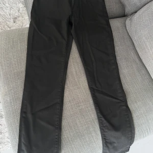 Oanvända Svarta Levis 511 - Säljer ett par svarta Levis 511 Slim jeans i bra skick. De är slim fit och sitter under midjan, perfekta för en stilren look. Tillverkade med Eco Ease-teknologi för en miljövänligare produktion. Passar både till vardags och fest!